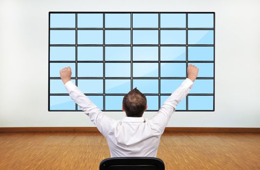 happy businessman looking on blank plasma in office