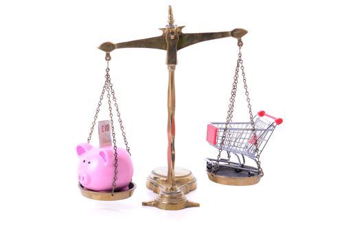 Saving on shopping concept piggy bank dn shopping cart on scales