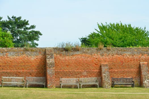 Wooden benches against brick wall