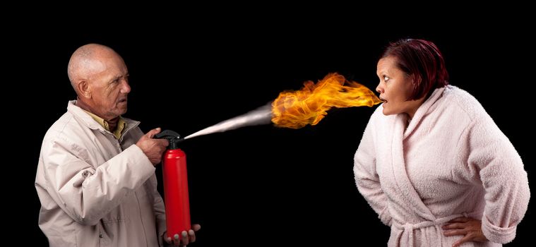An old man attempts to extinguish the flames that emanates from the mouth of a younger woman.