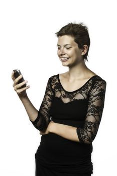 Young girl in black dress writing a short message (SMS) on their mobile phone, isolated on white background