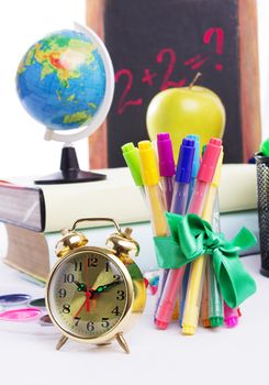 Some school stationary with clock isolated on white