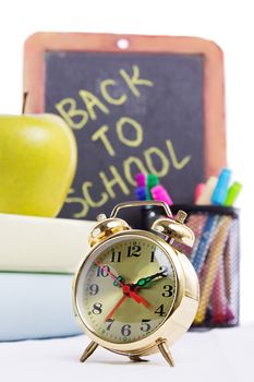 Back to school supplies with clock isolated on white