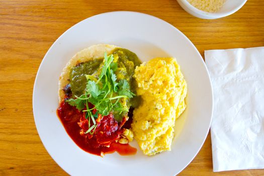 Huevos rancheros are served with eggs salsa and tortillas at a gourmet breakfast restaurant.
