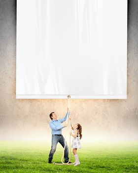 Man and little girl pulling banner. Place for text