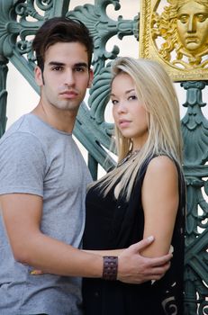 Attractive couple holding each other looking in camera, standing
