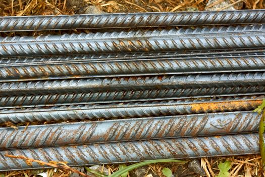 Group of parallel ribbed reinforcement rods lying on the ground