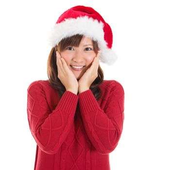 Joyful Asian Christmas woman wearing santa hat. Christmas woman portrait of a cute, beautiful smiling Asian Chinese / Japanese model. Isolated on white background.