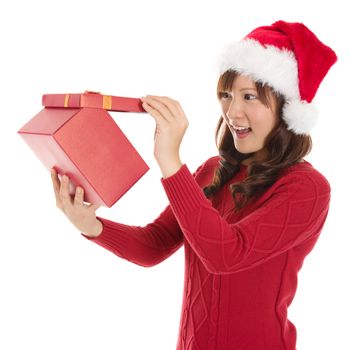 Christmas Gift - Asian woman opening gift surprised and happy, Young beautiful smiling woman in Santa hat. Funny cute photo of Asian woman isolated on white background