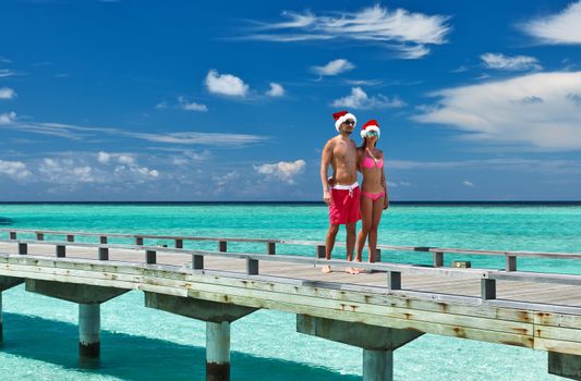 Couple on a tropical beach jetty at Maldives