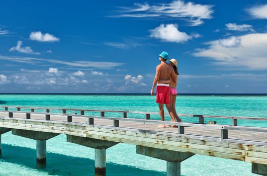 Couple on a tropical beach jetty at Maldives