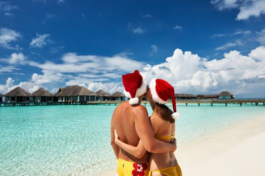 Couple in santa's hat on a tropical beach at Maldives