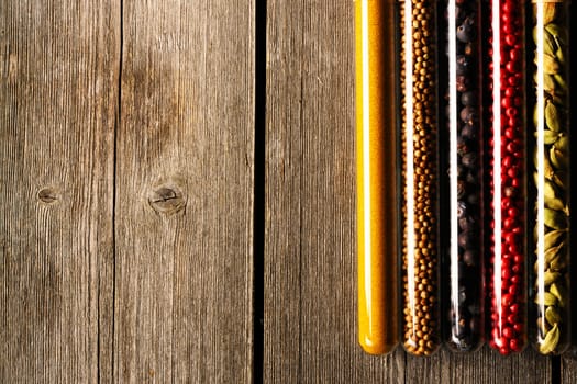 Spices in beakers on wooden background