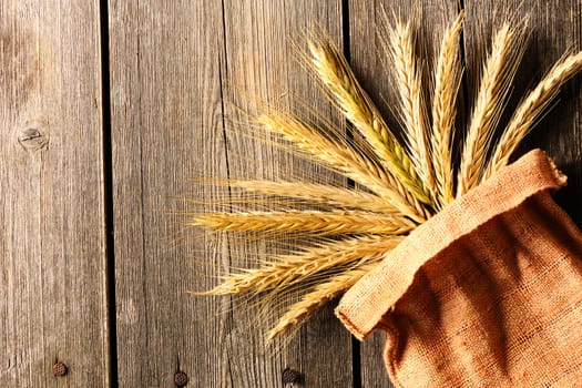 Rye spikelets on wooden background