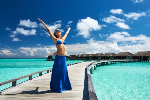 Woman on a tropical beach jetty at Maldives