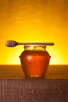 Honey jar with dipper on table  