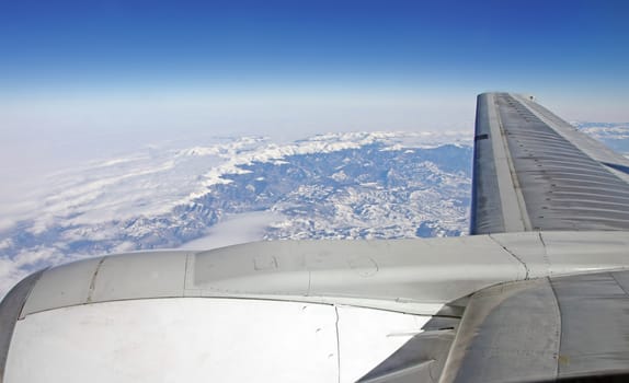 View from a jet plane, wings of the plane and mountains