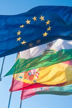 4 flags: the European Union, Andalucia, Spain, Granada, at the fortress of the Alhambra. Spain