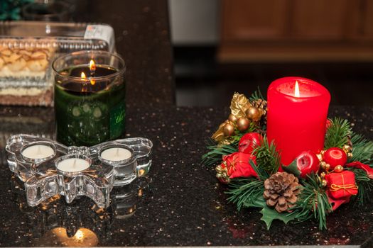 Christmas candle with ornaments on a table.