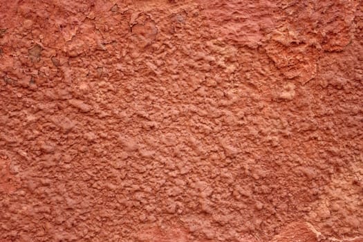 Detail of old red wall with shelled stucco