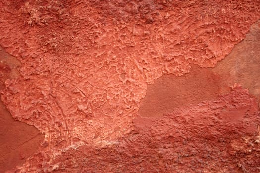 Detail of old red wall with shelled stucco