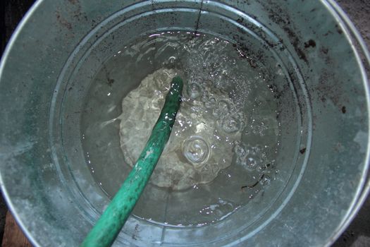 bucket with hose on water