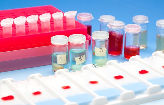 Array of blood samples for microscopy and biopsy tissue on blue gradient background