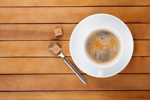 Coffee cup with lump sugar, wooden background