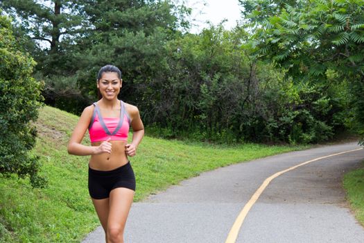 Smiling young woman running for fitness