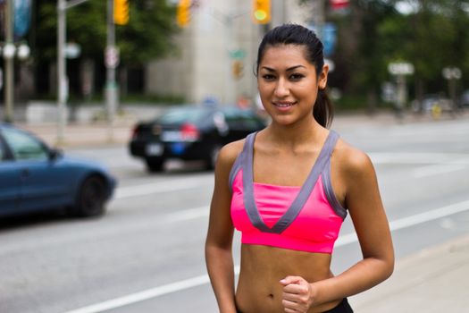 Fit young woman running on a busy city street