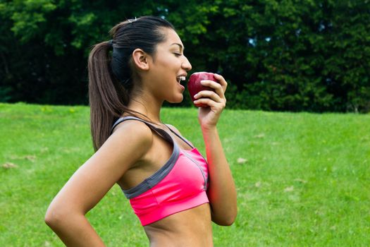 Fit young woman eating an apple