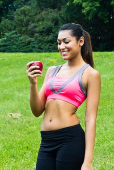 Fit young woman with an apple in the park