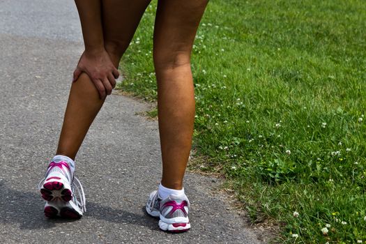 Young woman with running injury on calf