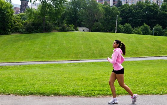 Fit woman running in the city park