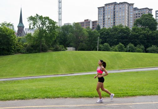 Fit woman running in the city park