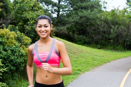 Smiling young woman running for fitness