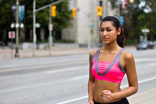 Fit young woman running on a busy city street