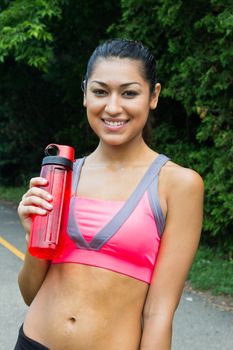 Fit young woman with water bottle after running