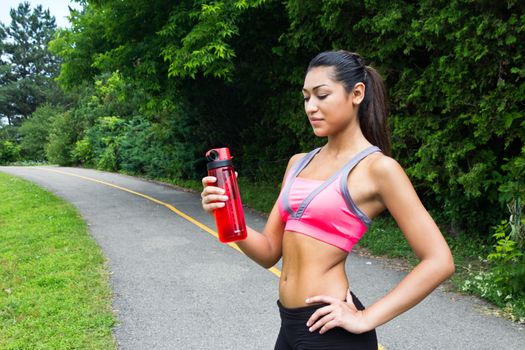 Fit young woman with water bottle after running