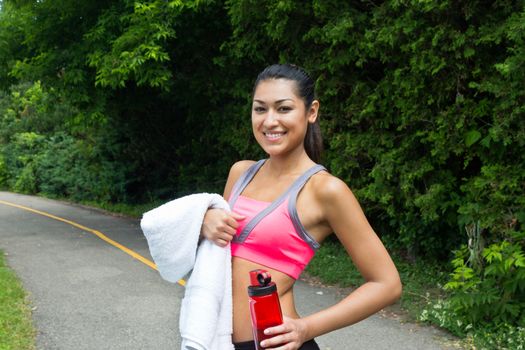 Fit woman rests with water and towel