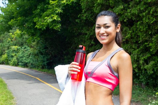 Fit woman rests with water and towel