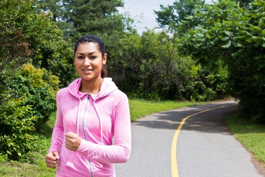 Young, atractive woman running on the nature trail