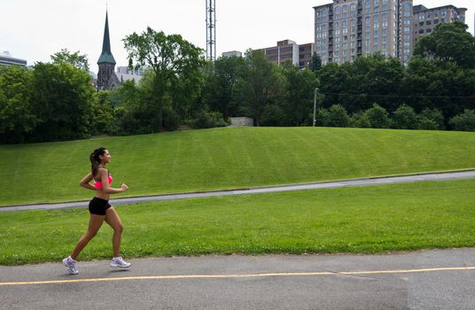 Fit woman running in the city park