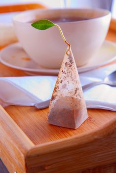 Pyramidal tea filter over a wooden tray