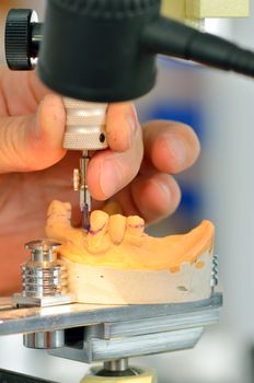 Dental technician measuring dentures in laboratory