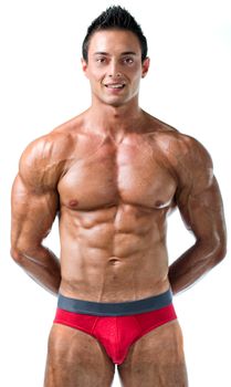 Handsome young bodybuilder in red swimming suit, showing ripped muscular body, isolated