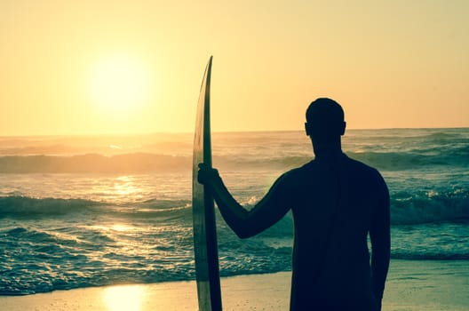 Surfer watching the waves at sunset in Portugal.