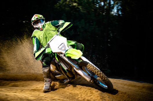 Enduro bike rider on action. Turn on sand terrain.