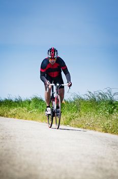 Man on road bike riding down open country road.