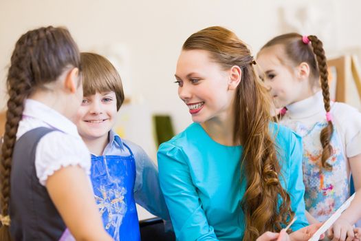 Little children painting and playing at kindergarten